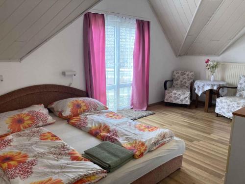 シオーフォクにあるApartment Siofok, Lake Balaton 1のベッドルーム1室(ベッド2台付)、ピンクのカーテン付きの窓が備わります。