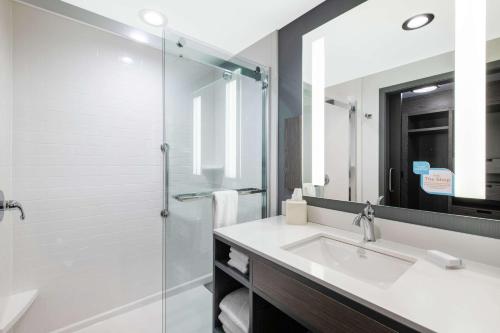 a bathroom with a sink and a glass shower at Hilton Garden Inn Pittsburgh Area Beaver Valley, Pa in Monaca