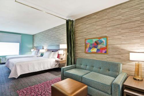ペコスにあるHome2 Suites By Hilton Pecos Txのベッドとソファ付きのホテルルーム
