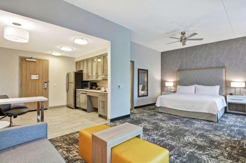 リンチバーグにあるHomewood Suites By Hilton Lynchburgのベッドとキッチン付きのホテルルーム