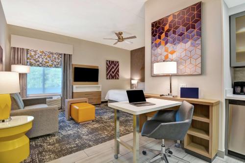 a hotel room with a bed and a desk with a laptop at Homewood Suites By Hilton Lynchburg in Lynchburg