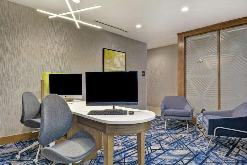an office with a desk with two monitors and chairs at Homewood Suites By Hilton Lynchburg in Lynchburg