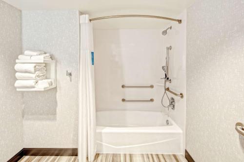 La salle de bains est pourvue d'une baignoire blanche et d'une douche. dans l'établissement Hampton by Hilton Encinitas-Cardiff Beach Area, à Encinitas