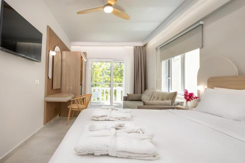 a white bedroom with a large bed with white blankets at Epavli Grace Hotel in Chania