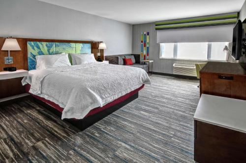 ein Hotelzimmer mit einem Bett und einem TV in der Unterkunft Hampton by Hilton Encinitas-Cardiff Beach Area in Encinitas