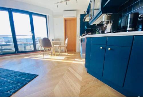 eine Küche mit blauen Schränken sowie einem Tisch und Stühlen in der Unterkunft Luxury 1 bedroom in Center with Terrace & Parking-51B in Luxemburg (Stadt)