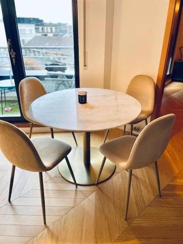 einen Tisch mit vier Stühlen und eine Kaffeetasse drauf in der Unterkunft Luxury 1 bedroom in Center with Terrace & Parking-51B in Luxemburg (Stadt)