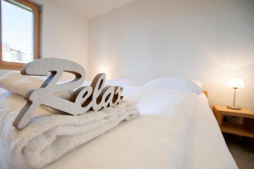 a white bed with white blankets and towels on it at Haus Bella Vista in Riederalp