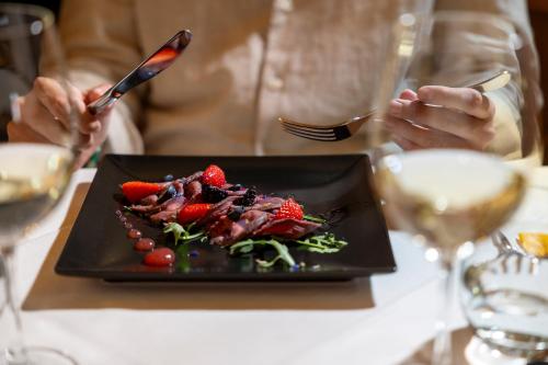 a person sitting at a table with a plate of food at Hotel Ramon in Campitello di Fassa