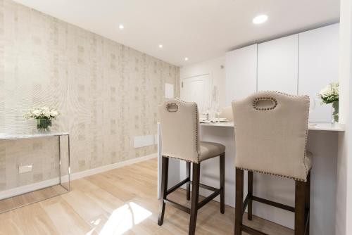 2 sillas en una cocina con armarios blancos en The Terraces Luxury Penthouses, 3B, en Santa Cruz de Tenerife