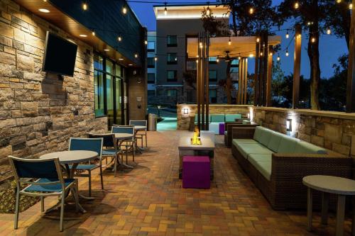 a patio with tables and chairs in a building at Hilton Garden Inn Cedar Park Austin in Austin