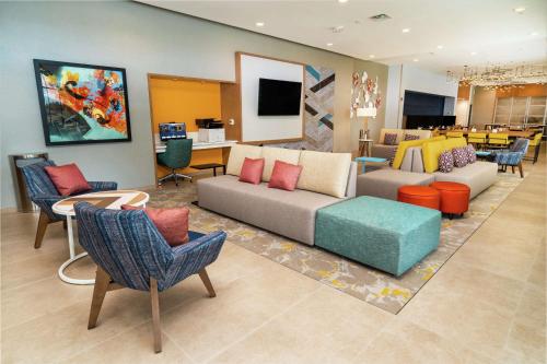 a living room with a couch and tables and chairs at Hilton Garden Inn Cedar Park Austin in Austin