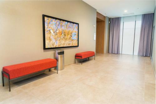 a waiting room with two benches and a painting on the wall at Hilton Garden Inn Cedar Park Austin in Austin