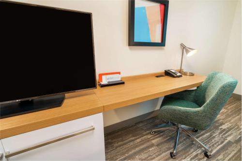 a room with a desk with a television and a chair at Hilton Garden Inn Cedar Park Austin in Austin