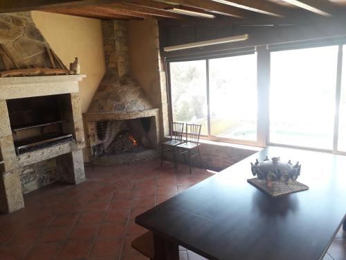 a living room with a stone fireplace and a table at Casanova1914 in Villatuge