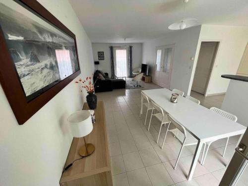 维桑Belle maison de famille - Wissant的客厅里有一张白色的桌子和椅子