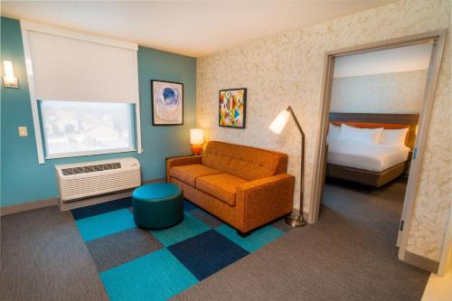 Habitación de hotel con sofá y cama en Home2 Suites Bakersfield, en Bakersfield