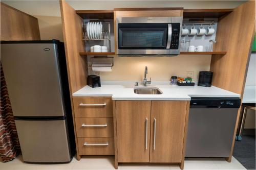 a small kitchen with a sink and a microwave at Home2 Suites Bakersfield in Bakersfield