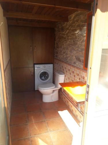 a bathroom with a toilet and a washing machine at Casanova1914 in Villatuge