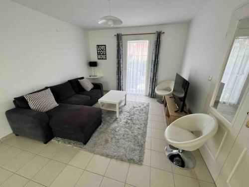 维桑Belle maison de famille - Wissant的客厅里有一张黑色沙发和一台电视