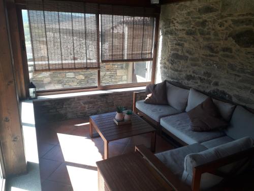 a living room with a couch and a brick wall at Casanova1914 in Villatuge