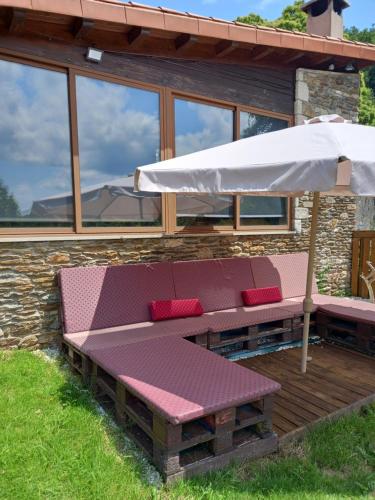 a bench with an umbrella on a deck at Casanova1914 in Villatuge