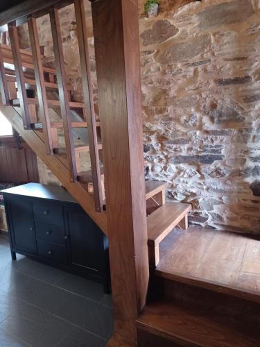 a wooden staircase in a room with a stone wall at Casanova1914 in Villatuge