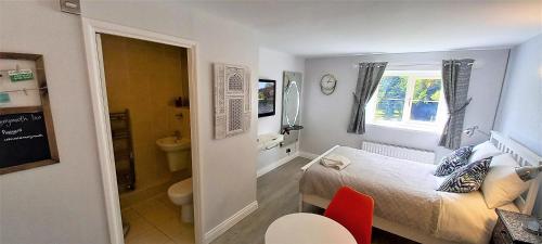 ein kleines Schlafzimmer mit einem Bett und einem Badezimmer in der Unterkunft Cotswold Merrymouth Inn in Bourton on the Water