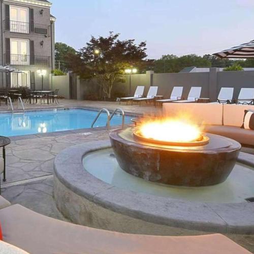 a fire pit in front of a swimming pool at The Burgundy Hotel, Tapestry Collection by Hilton in Little Rock