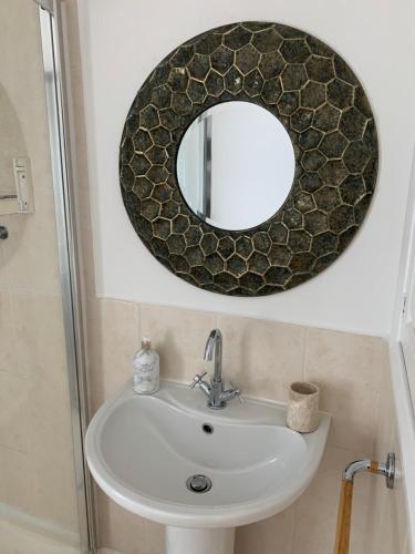 a bathroom with a mirror and a sink at The Apartment, Bridge House in Laxey