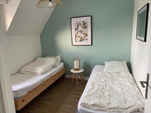 a bedroom with two beds and a small table at Maison Familiale - Plage à Pieds in Larmor-Plage