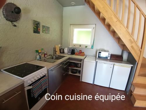 une cuisine avec un évier et une cuisinière four supérieur dans l'établissement Le Fouzon, à Meusnes