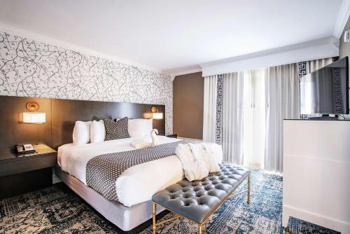 a hotel room with a bed and a television at The Burgundy Hotel, Tapestry Collection by Hilton in Little Rock