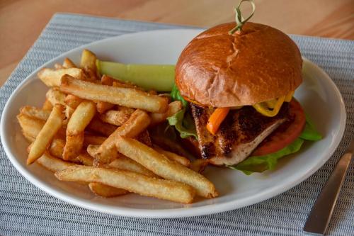 a white plate with a sandwich and french fries at DoubleTree by Hilton Oceanfront Virginia Beach in Virginia Beach