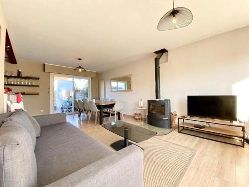 un salon avec un canapé et une télévision dans l'établissement Maison Familiale - Plage à Pieds, à Larmor-Plage