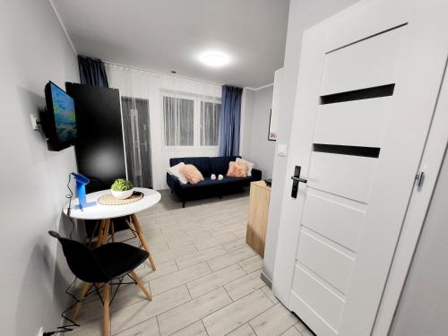a room with a door and a table and a couch at Mini Apartamenty Poznań in Poznań
