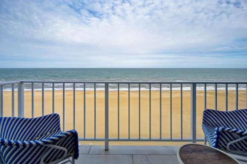 two chairs on a balcony looking at the beach at DoubleTree by Hilton Oceanfront Virginia Beach in Virginia Beach