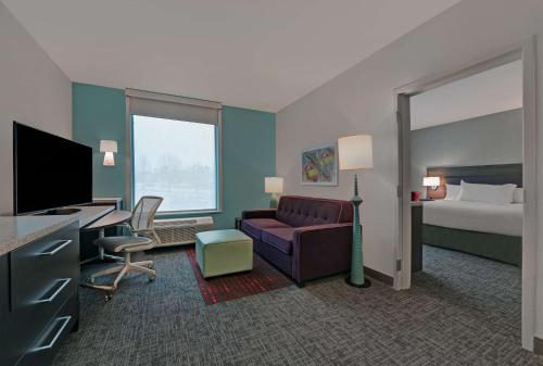 a hotel room with a bed and a couch and a desk at Home2 Suites By Hilton Memphis Wolfchase Galleria in Memphis