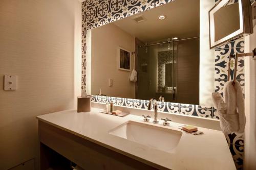 a bathroom with a sink and a large mirror at DoubleTree by Hilton Oceanfront Virginia Beach in Virginia Beach