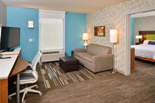a hotel room with a bed and a desk and a chair at Home2 Suites By Hilton Portland Hillsboro in Hillsboro