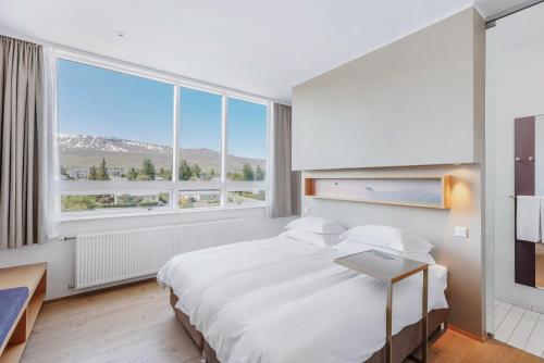 a bedroom with a bed and a large window at Akureyri - Berjaya Iceland Hotels in Akureyri