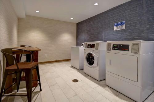 a laundry room with two washing machines and a stool at DoubleTree by Hilton Oceanfront Virginia Beach in Virginia Beach