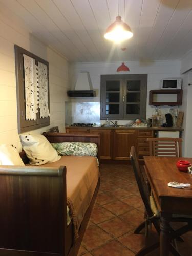 a bedroom with a bed and a kitchen with a table at LES CASES METISSES in Saint-Louis