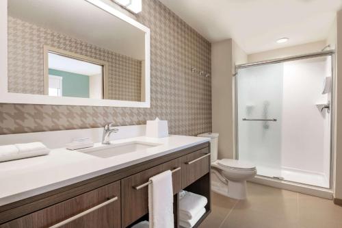 W łazience znajduje się umywalka, toaleta i lustro. w obiekcie Home2 Suites By Hilton Rochester Greece w mieście Greece