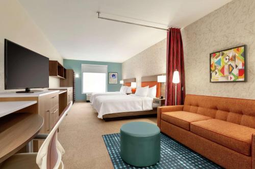 Habitación de hotel con cama y sofá en Home2 Suites By Hilton Rochester Greece en Greece