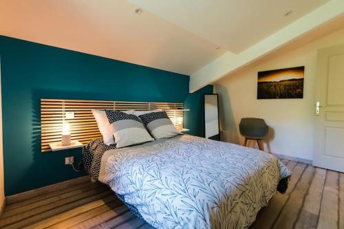 ein Schlafzimmer mit einem großen Bett mit blauer Wand in der Unterkunft Charmante maison de village au cœur de Saint-Rémy in Saint-Rémy-de-Provence