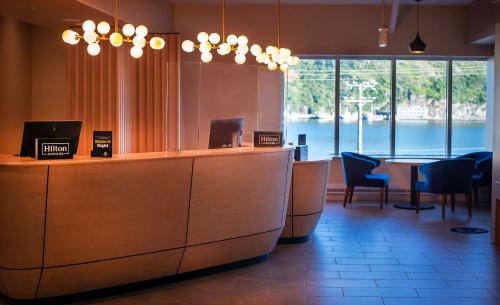 un restaurant avec un bar offrant une vue sur l'eau dans l'établissement DoubleTree by Hilton St. John's Harbourview, à Saint-Jean