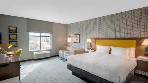 um quarto de hotel com uma cama grande e um sofá em Hampton Inn Riverside Downtown em Riverside