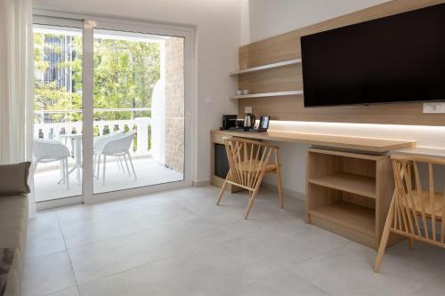 a living room with a television and a table with chairs at Epavli Grace Hotel in Chania Town