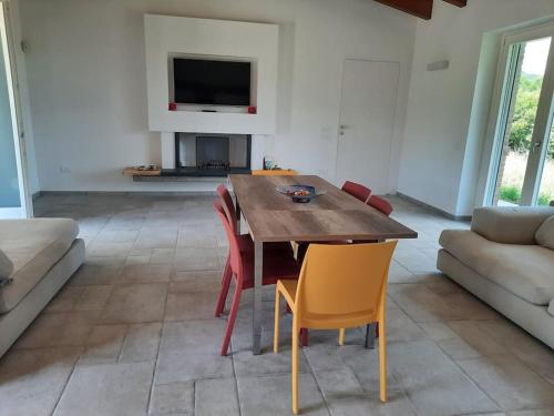 ein Wohnzimmer mit einem Holztisch und Stühlen in der Unterkunft VILLA MILLEFIORI in Tornareccio